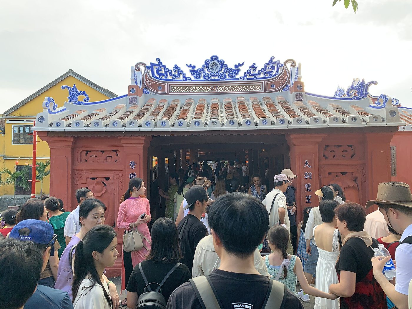 The western portal days after reopening in 2024: bright vermilion walls, blue-and-white ceramic ridge, a crowd pressing through the doorway.
