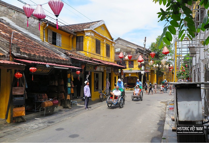 The same junction dry in 2022, hung with lanterns, cyclos and walkers along Nguyễn Thái Học street.